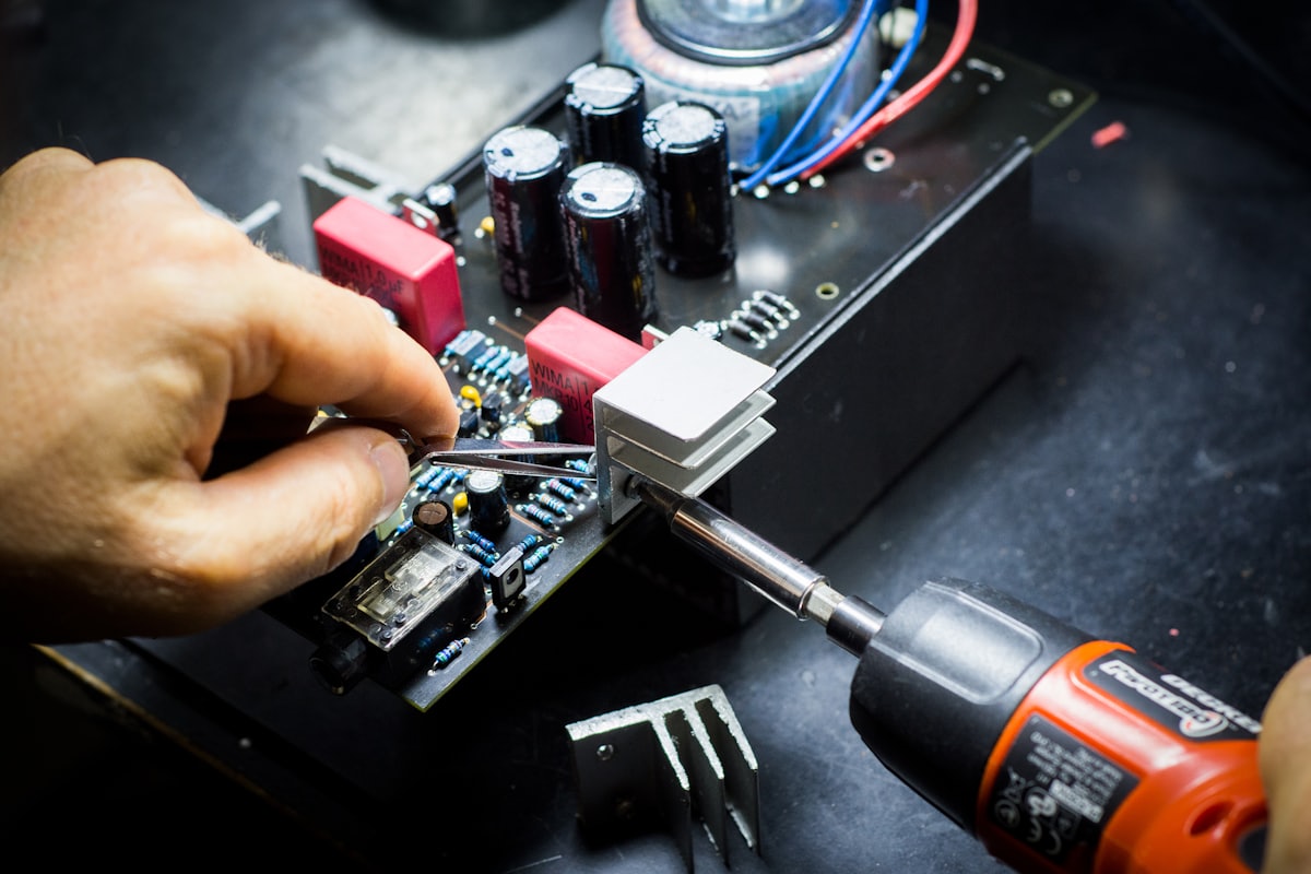 Hands assembling a power electronics board with heat sink